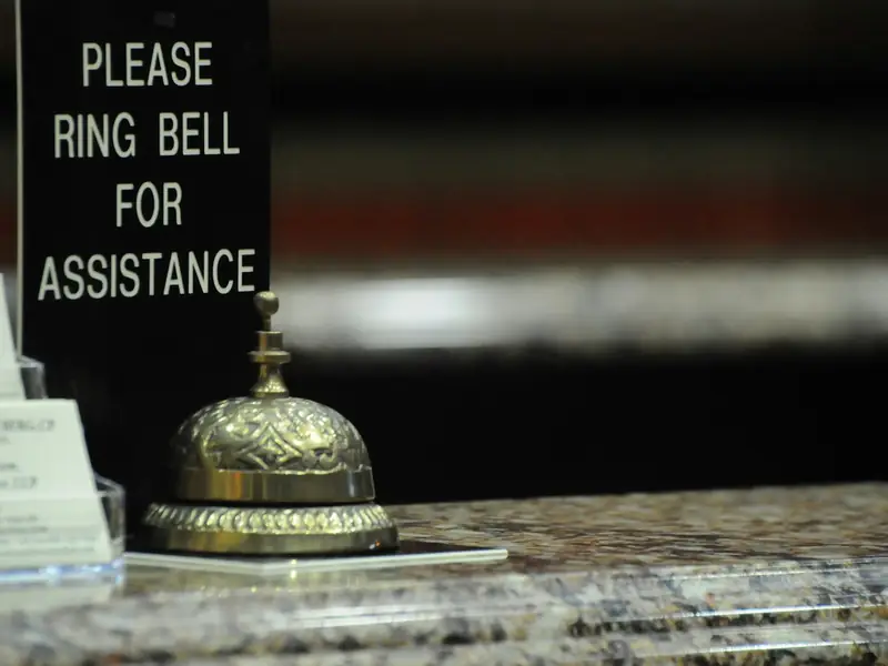 A service bell next to a 'Please ring bell for assistance' sign