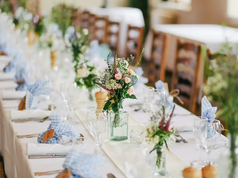 A long wedding table set with flowers and glassware