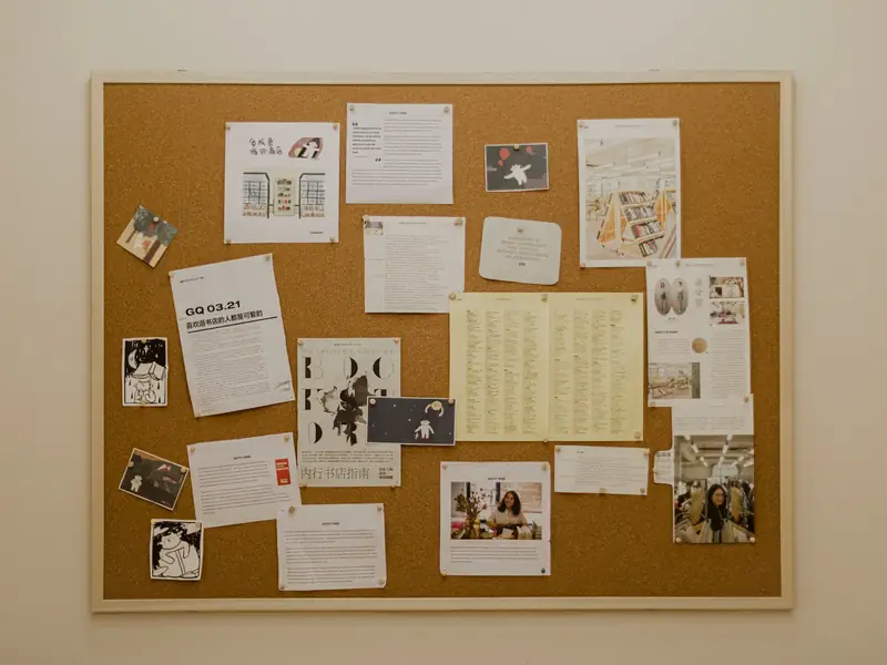 A cork notice board covered with flyers
