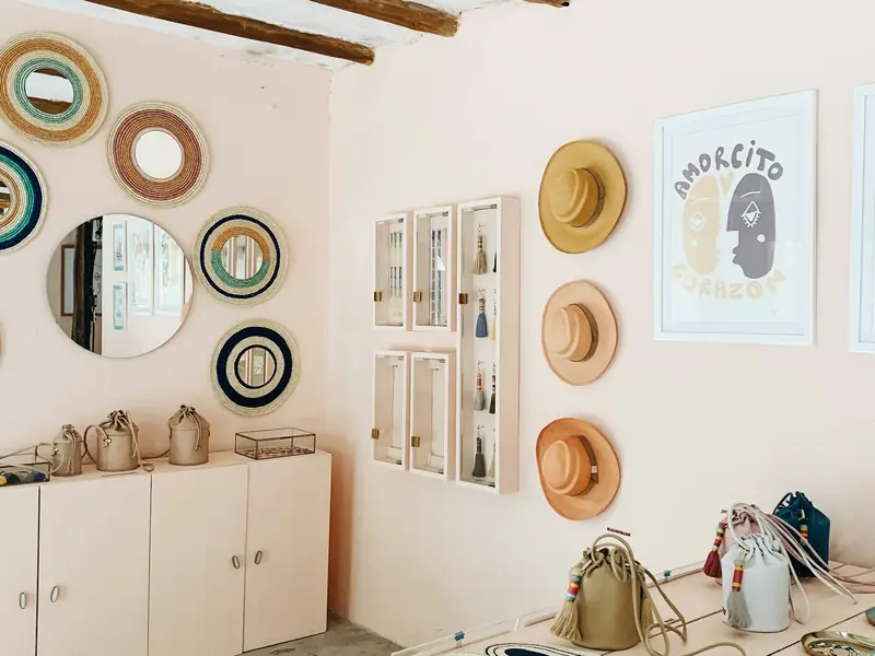 A small boutique with hats, bags and mirrors on display