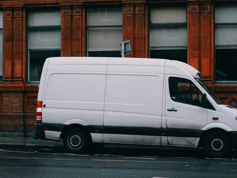 A white delivery van parked on a city street
