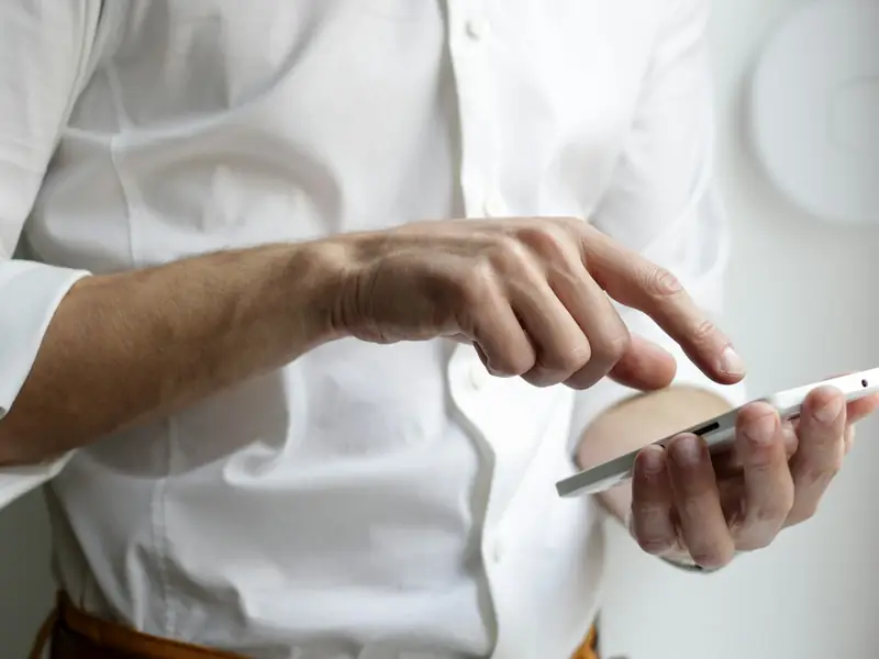 Hands typing a message on a smartphone