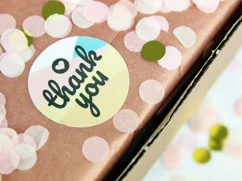 A round thank-you sticker on a parcel