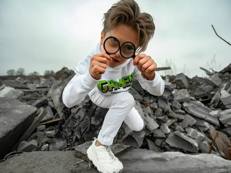 A child looking through a toy magnifying glass on a treasure hunt