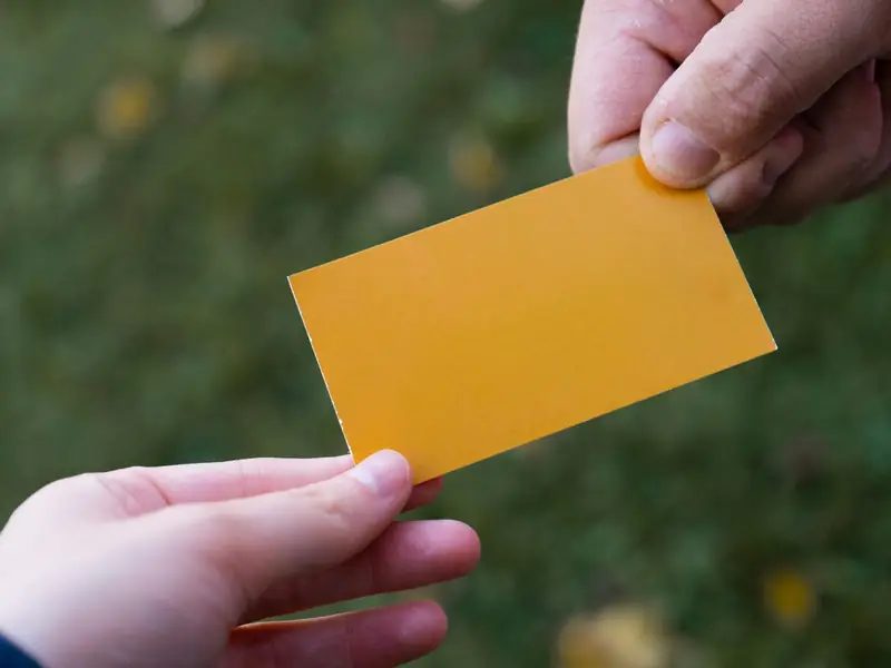 One person handing a business card to another