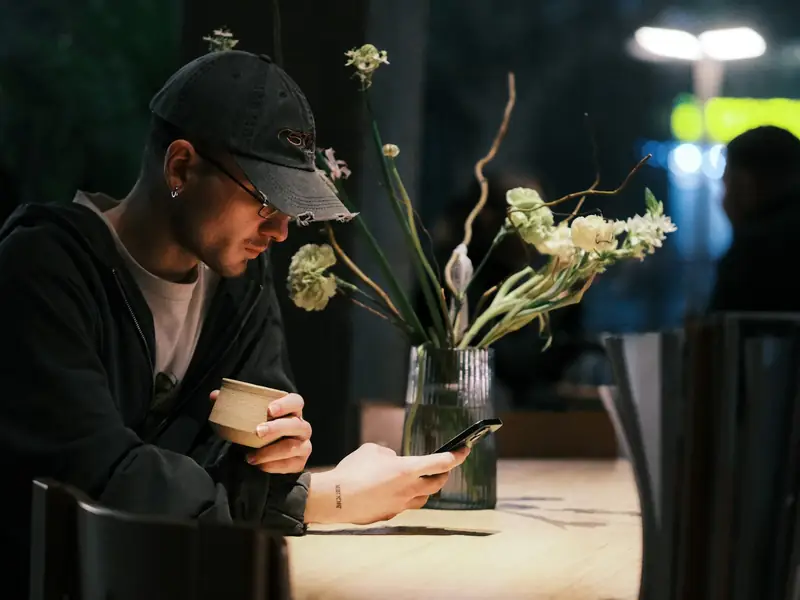 A guest using his phone at a restaurant table
