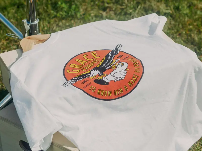 A printed band T-shirt laid out on the grass